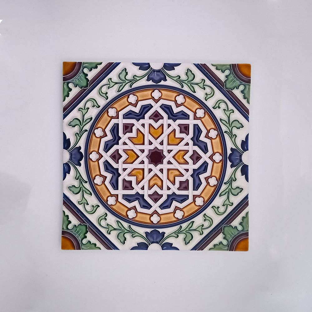 The Azores Tiles and Decor by Tejo Shop features a hand-painted square ceramic tile with intricate gold, green, blue, and white interlocking geometric patterns—ideal as a unique backsplash accent.