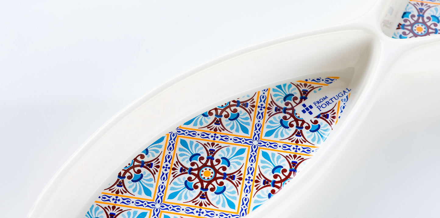 The Olives serve ‘Sardine' 04’ Dish by ObjectoAnonimo is a white Portuguese ceramic dish with blue, yellow, and red geometric tile patterns inside and a FROM PORTUGAL label.