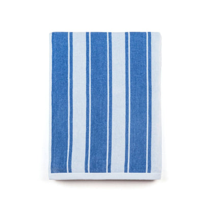The Torres Novas Blue Meco Stripes Beach Towel 430 GSM, with wide and narrow vertical blue and white stripes inspired by Portuguese coastal design, is neatly folded on a plain white background.