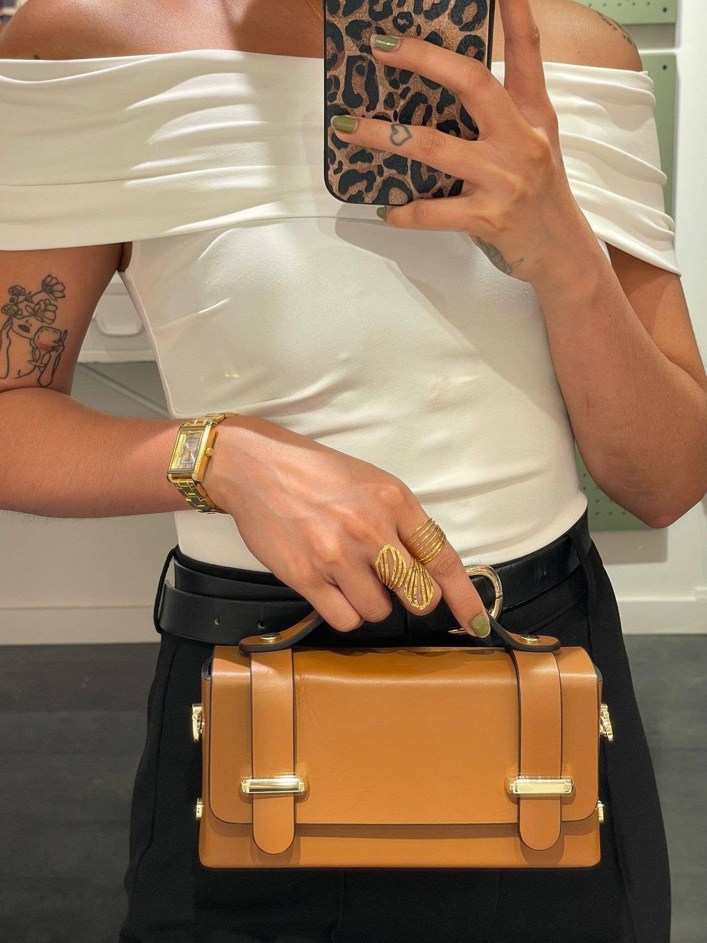 Lifestyle photo of the Carmel genuine leather bag in Camel being held by a model, showing size and top-handle detail.