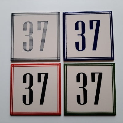 TilePassion’s Handpainted Ceramic Door Numbers – Custom Portuguese Tiles come as four black-on-white tiles, each with a distinct border (gray, blue, red, or green) in a 2x2 grid—ideal for personalized address plaques.