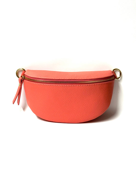 Cassette fanny pack/crossbody in coral Italian leather with gold zip and matching strap, front view on white.