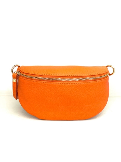 Cassette fanny pack/crossbody in tangerine Italian leather with gold zip and matching strap, front view on white.