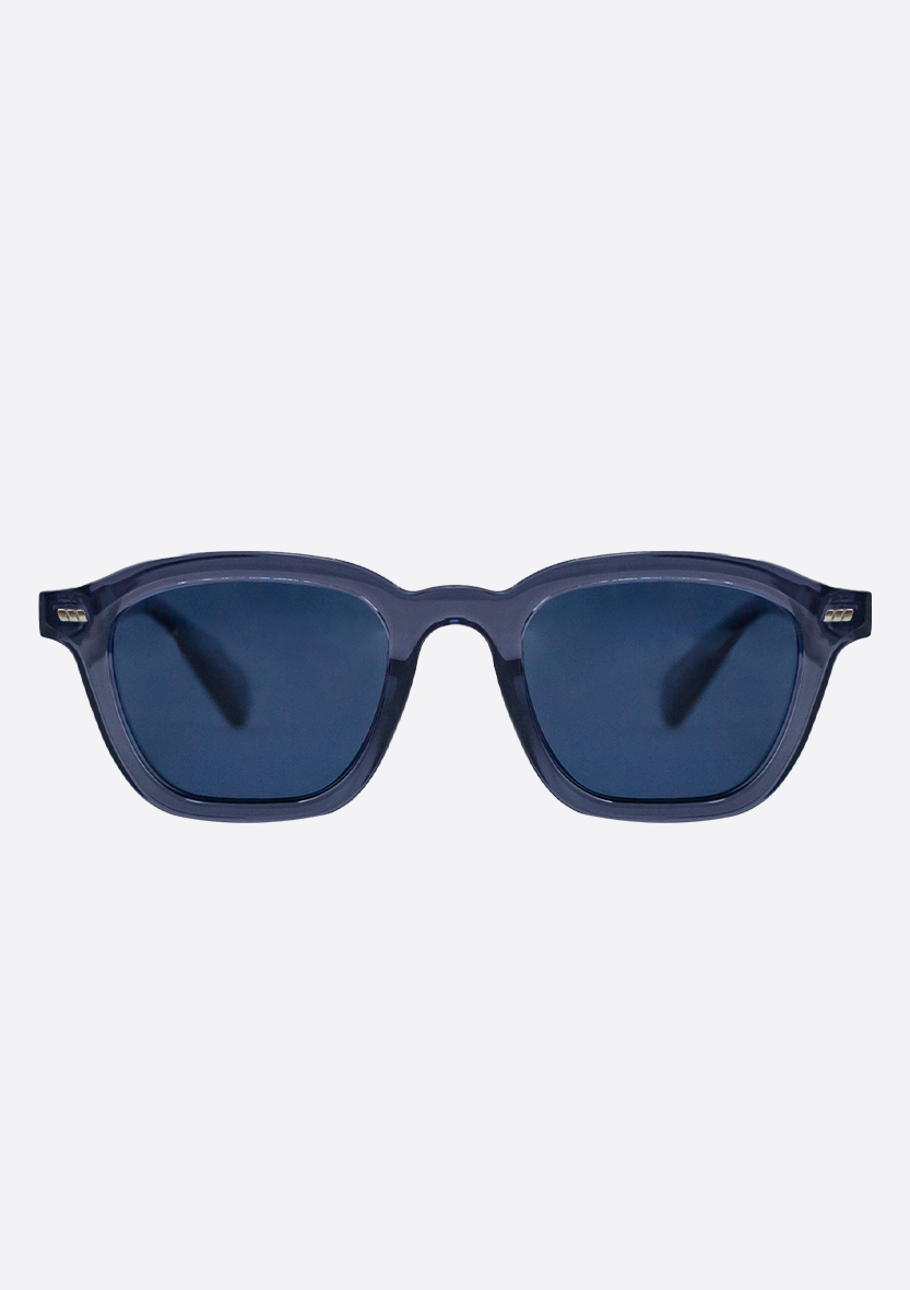 The Oceanides Neda Crystal Blue Sunglasses feature thick recycled plastic frames, dark polarized lenses, and a rectangular shape, shown on a plain light background.