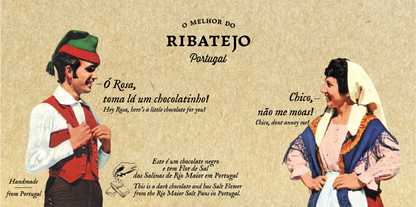 A man and woman in traditional Portuguese dress smile at each other against a beige background featuring English and Portuguese text that highlights O Melhor do Ribatejo’s Dark Chocolate with Flor de Sal, a tribute to Portugal’s culinary mastery.