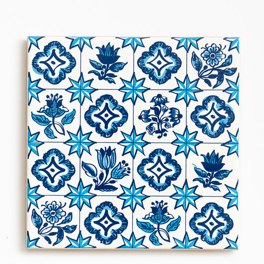 The ObjectoAnonimo Ceramic drinks coaster 11cm - Azulejo 21 features a repeated blue floral and eight-pointed star pattern on white, with dark and light blue shades, creating a vibrant ceramic accent for your table.