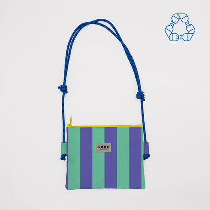 A striped crossbody bag with vertical purple and mint green stripes, a blue rope shoulder strap, and a yellow zipper trim. The brand label reads 'LOFT'.