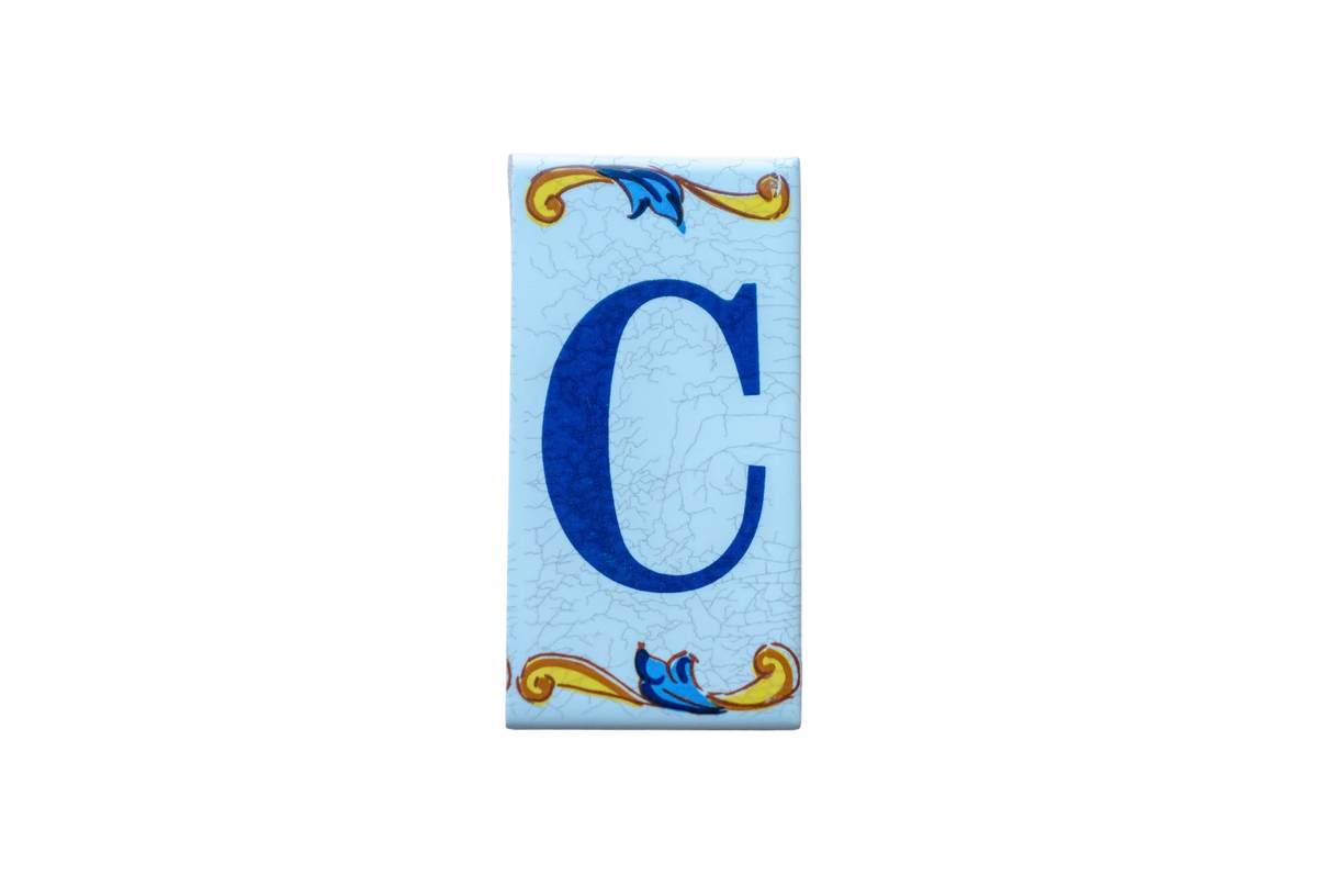 Lisa Croquets Letters – Ceramic House Letter Tile featuring a rectangular Spanish design with a blue letter C and decorative yellow and blue scrollwork borders.