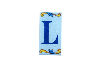 Lisa Croquets Letters – Ceramic House Letter Tile featuring the blue letter L on a light blue crackled background with decorative yellow and blue scrollwork.
