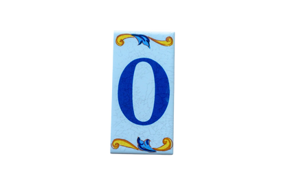 Lisa Croquets Letters – Ceramic House Letter Tile featuring the number zero in blue, with rectangular handcrafted edges and decorative blue and yellow scrollwork at the top and bottom.