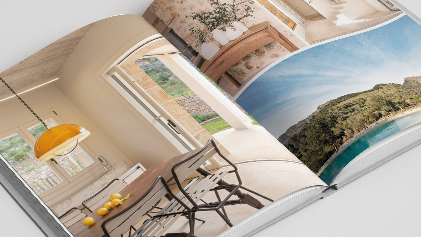 The book "Mallorca Living" by Loft Publications showcases stylish home interiors bathed in natural light, rustic furniture, fresh lemons, potted plants, and scenic coastal views inspired by Mallorca architecture.