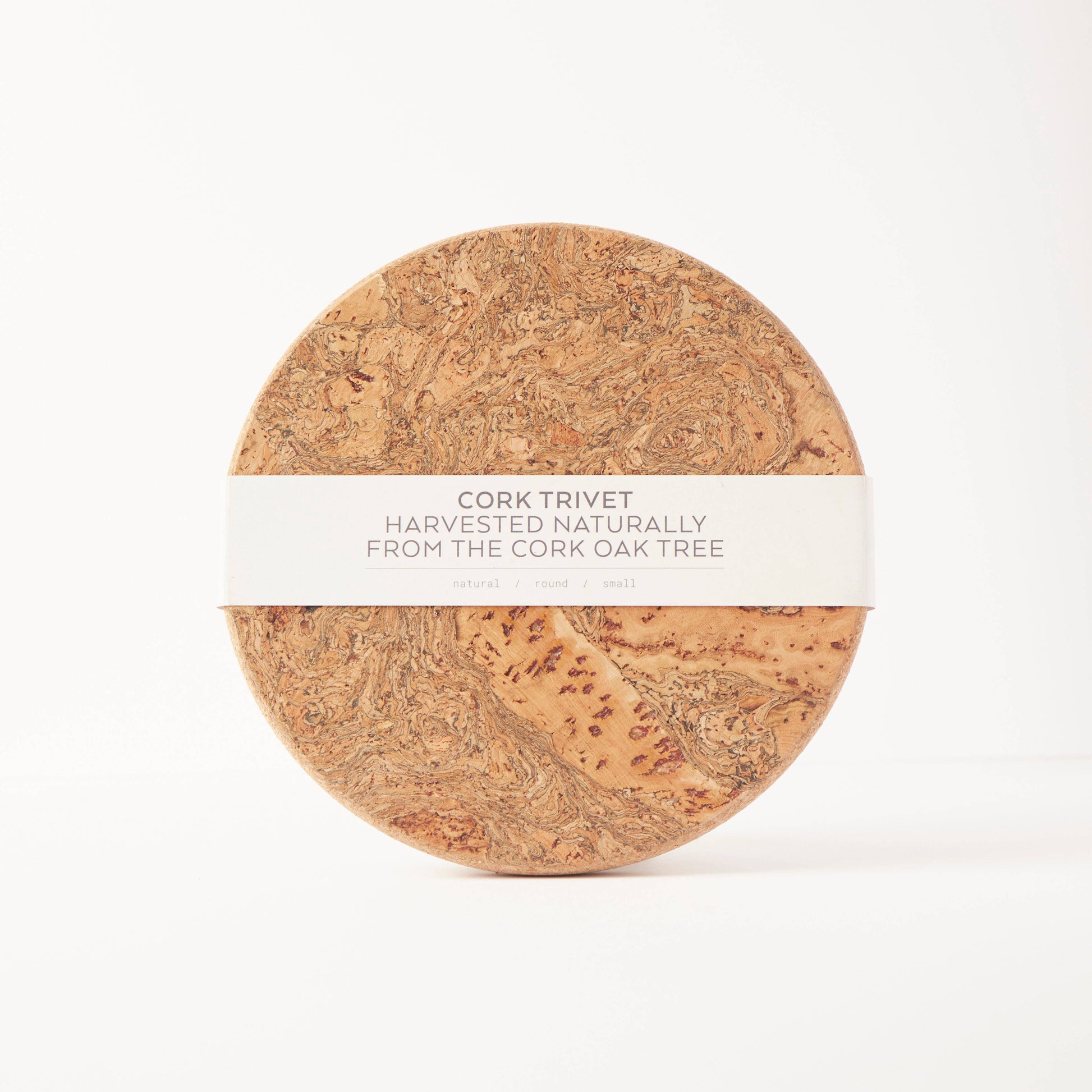 The LIGA Natural Cork Trivet - Round Small, labeled "Eco Sustainable Homeware" and made from cork oak, features a marbled finish and comes wrapped in a white band, offering an eco-friendly choice against a plain white background.