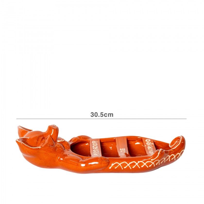 The Ceramica Picas Terracotta Chorizo Pig Roaster is a 30.5 cm brown ceramic, boat-shaped dish with a pig figure on one end, decorated with white patterns and text.