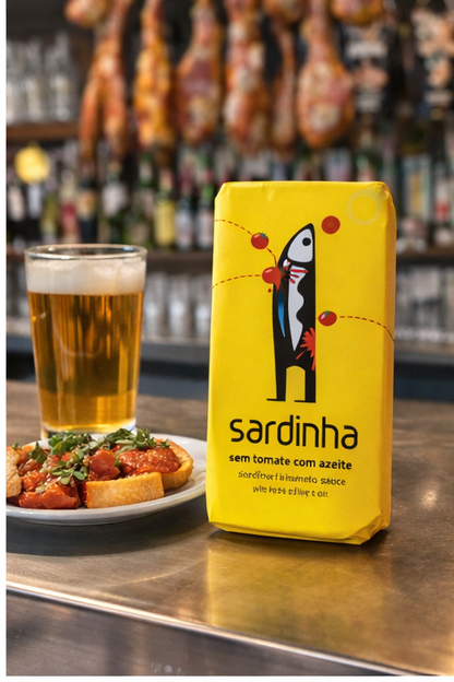 A tin of Sardinha Sardines in Tomato sits on a bar counter beside a glass of beer and food, with cured meats and shelves blurred in the background, highlighting this tasty omega 3-rich delight.
