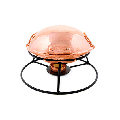 The Iberica - Pretty things from Portugal Cataplana Starter Kit features a dome-shaped, hammered copper cataplana pan with handles on a black metal stand and a vented lid, perfect for authentic Portuguese tabletop cooking and serving on a plain white background.