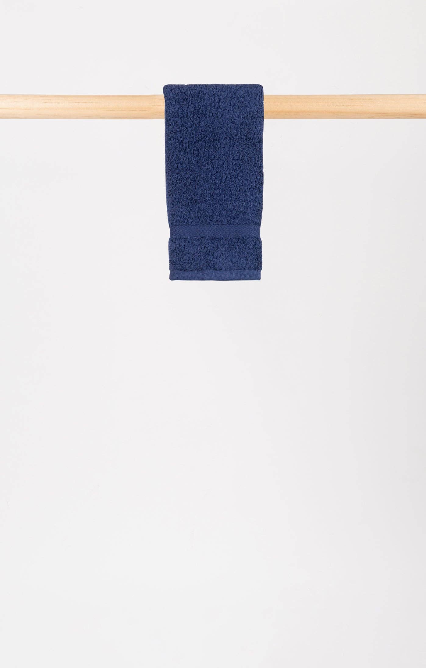 cobalt blue hand towel hanging on a wooden rail